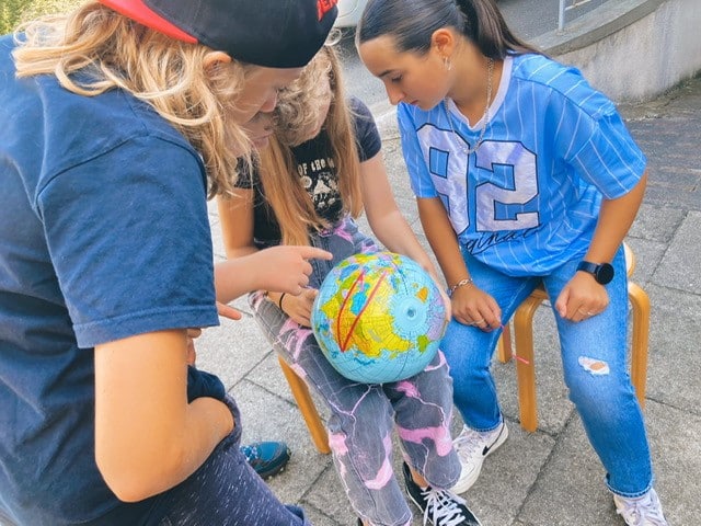 Kinder schauen einen Globus an