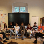 junge Menschen sitzen in einem Seminarraum im Stuhlkreis
